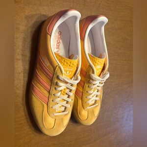 Adidas Gazelle sneakers in a saffron/mustard yellow and coral pink